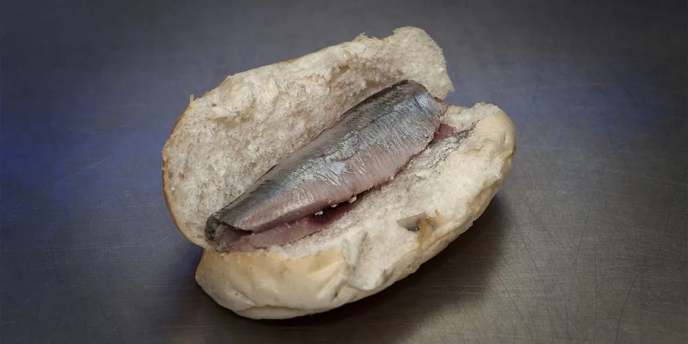 Een broodje haring op donker staal