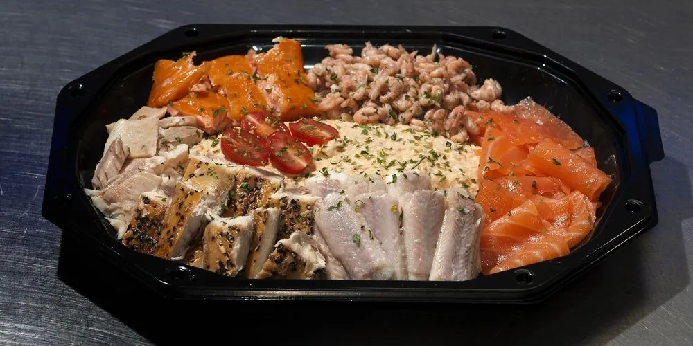 Een opgemaakte visschotel met zalm, paling, makreel en garnalen