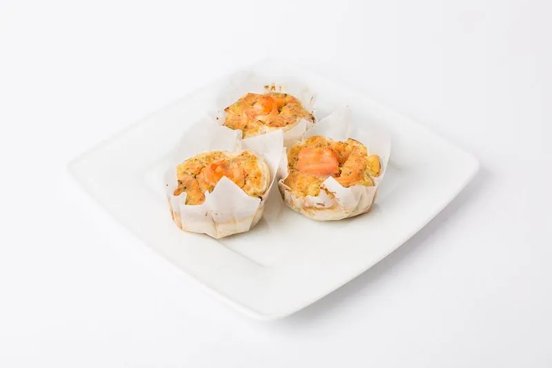 Mini quiches met zalm en broccoli op een wit bord